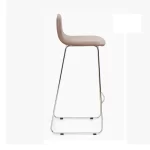 Vista lateral. Taburete tapizado beige, base trineo cromada